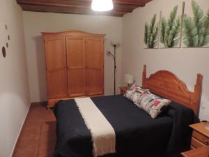 Un dormitorio con una cama y un armario de madera. en Estudio Plaza San Sebastián, en Santa Cruz de la Palma