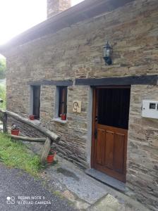 ein Steinhaus mit einer Holztür davor in der Unterkunft Casa rural "Matela" in Prado