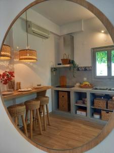 a mirror reflecting a kitchen with a counter and stools at Patmos Little Suites in Skala