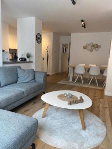 a living room with a couch and a table at Quality Time appartement met gesloten garagebox in De Panne