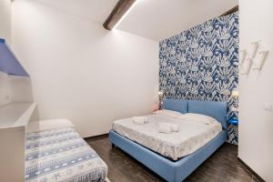 a small bedroom with a blue bed and a wall at Blu Mare Apartment in Vernazza