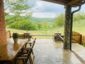 Gnjilane的住宿－Villa SEMI，庭院配有木桌、椅子和围栏