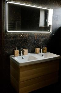 a bathroom with a white sink and a mirror at APARTMÁNY za divadlem in Broumov