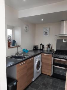 a kitchen with a sink and a washing machine at Laston Mews in Ilfracombe