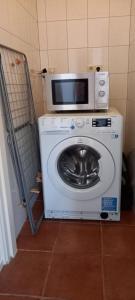 uma máquina de lavar roupa com um micro-ondas em cima em Beachloft Zeeland 1 em Scharendijke