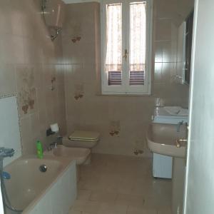 uma casa de banho com um lavatório, um WC, uma banheira e uma janela. em vale countryhouse 10 minuti dal mare 10 minuti dalla montagna em Ascoli Piceno
