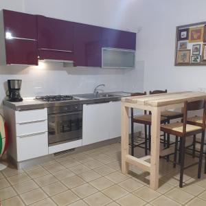 uma cozinha com um lavatório, um fogão e uma mesa em vale countryhouse 10 minuti dal mare 10 minuti dalla montagna em Ascoli Piceno