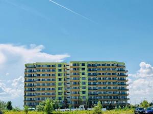 a tall yellow building with cars parked in front of it at Summerland Studios Nuba in Mamaia