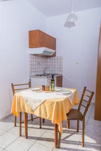 a kitchen with a table with a yellow table cloth at Arsinoi Studios and Apartments in Kalamaki
