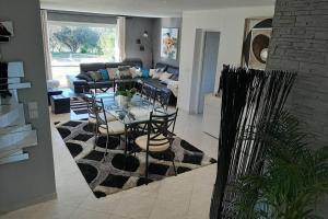 una sala de estar con una mesa y un sofá en Très belle villa piscine jacuzzi grande propriété 10 pers, en Belgodère