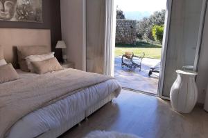 Un dormitorio con una cama y una puerta corrediza de vidrio. en Très belle villa piscine jacuzzi grande propriété 10 pers, en Belgodère 68 fotos más