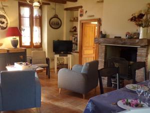 Una sala de estar con chimenea y televisión. en Gite Forestier Gentil, en Chanteloup-les-Bois