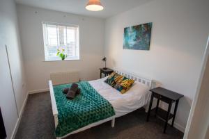 a bedroom with a bed with a teddy bear on it at Cherry Tree, Centrally Located Warrington Town Centre in Warrington