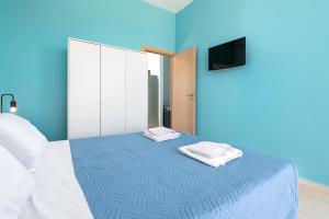 Una habitación azul con una cama con dos toallas. en Rhodes Sea Ialysos Apartment, en Ialisos