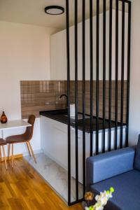 ein Wohnzimmer mit einem Tisch und einem Sofa sowie eine Küche in der Unterkunft RELAX LUX studio in Jagodina