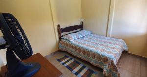 een slaapkamer met een bed, een bureau en een televisie bij CASA GIRASSOL-Trilha das Flores-SERRA DA CANASTRA in São Roque de Minas