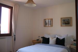 een slaapkamer met een bed met zwart-witte kussens bij Casa Cecilia, 2 bedrooms, 1 bathroom, lake view, pool in Gardone Riviera