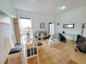 a living room with a table and a dining room at Cuyagua in Corralejo