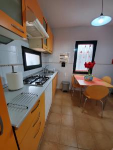 a kitchen with a stove and a table in it at Cuyagua in Corralejo +6 photos