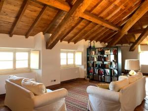 a living room with white furniture and wooden ceilings at Castello di Rocca Grimalda in Rocca Grimalda
