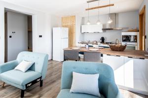 a kitchen and living room with two chairs and a table at Moho Mountain Home in Gérardmer