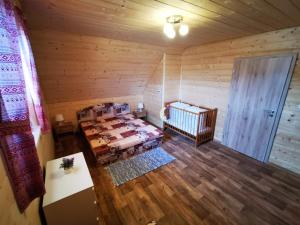 a room with a bed and a crib in a cabin at Chata BAŠKA na Liptove s vlastným dvorom in Liptovský Mikuláš