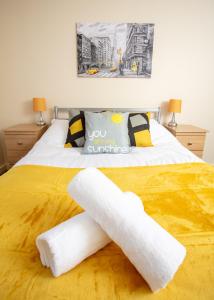 a bed with two white towels on it at Ample Comforts, Centrally Located, Town Centre in Warrington