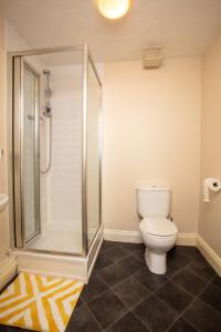 a bathroom with a shower and a toilet in it at Ample Comforts, Centrally Located, Town Centre in Warrington