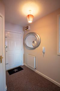 einen Flur mit einer weißen Tür und einem Spiegel in der Unterkunft Ample Comforts, Centrally Located, Town Centre in Warrington