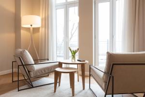 a living room with a table and chairs and a window at Vju Hotel Rügen in Göhren