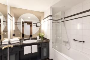 a bathroom with a sink and a shower and a mirror at Vju Hotel Rügen in Göhren