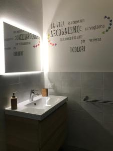 La salle de bains est pourvue d'un lavabo blanc et d'un miroir. dans l'établissement Home Sweet Home, à Scandicci
