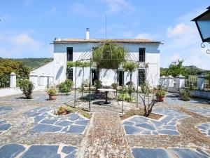Biały dom z ogrodem przed nim w obiekcie Holiday Home in Aracena with Private Pool w mieście Aracena