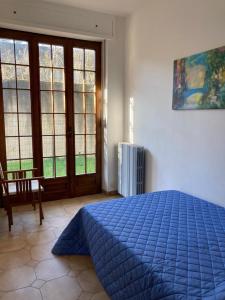 a bedroom with a blue bed and a window at VILLA FERNANDO in Castagnole Lanze