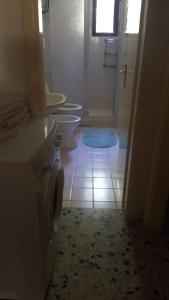 łazienka z 2 toaletami i niebieskim dywanem w obiekcie Casa Vacanza Santorsola w mieście Trinità dʼAgultu
