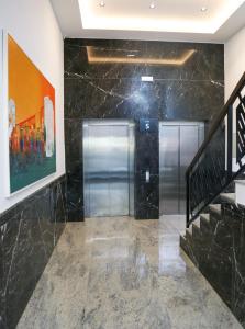 eine Lobby mit zwei Aufzügen und einer Marmorwand in der Unterkunft Central Luxury Apartment in Pristina