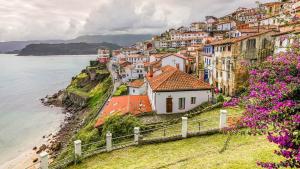 a village on a hill next to the ocean at Mirador del Cantabrico in Lastres