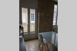 a dining room with a table and a balcony at Maison de ville dans une citée médiévale in Gourdon-en-quercy