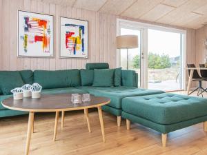 a living room with a green couch and a table at 6 person holiday home in Fan in Sønderho