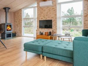 sala de estar con sofá azul y TV en 6 person holiday home in Fan, en Sønderho