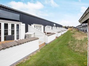 una fila de edificios blancos con un patio verde en 6 person holiday home in Vestervig en Vestervig