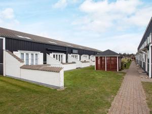 a row of buildings with a grass yard at 6 person holiday home in Vestervig in Vestervig