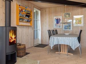 a dining room with a table and a fireplace at 8 person holiday home in Harbo re in Harboør