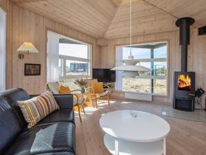 a living room with a couch and a table and a fireplace at 8 person holiday home in Harbo re in Harboør