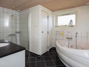 a white bathroom with a tub and a sink at 8 person holiday home in Vestervig in Vestervig