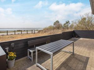 a bench sitting on top of a wall next to the beach at 8 person holiday home in Vestervig in Vestervig