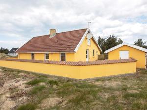 una casa amarilla con techo marrón en un campo en 10 person holiday home in Thisted, en Nørre Vorupør