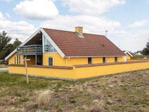 une maison jaune avec un toit marron sur un champ dans l'établissement 10 person holiday home in Thisted, à Nørre Vorupør