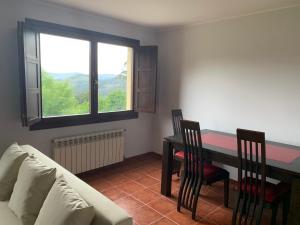 a living room with a couch and a table with chairs at Apartamentos La Peral in La Peral