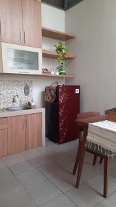 a kitchen with a black refrigerator and a table at Villa Blossom Kayana Regency E7 in Batu